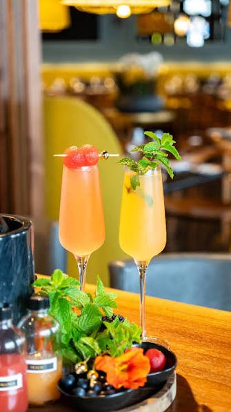 A tall Mimosa Tower being poured at a Southern brunch restaurant table